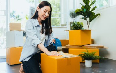 Asian woman packing box to move new home